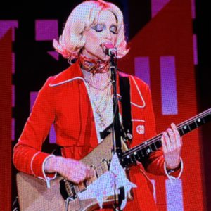 St. Vincent singing into their microphone at Ascend Amphitheater
